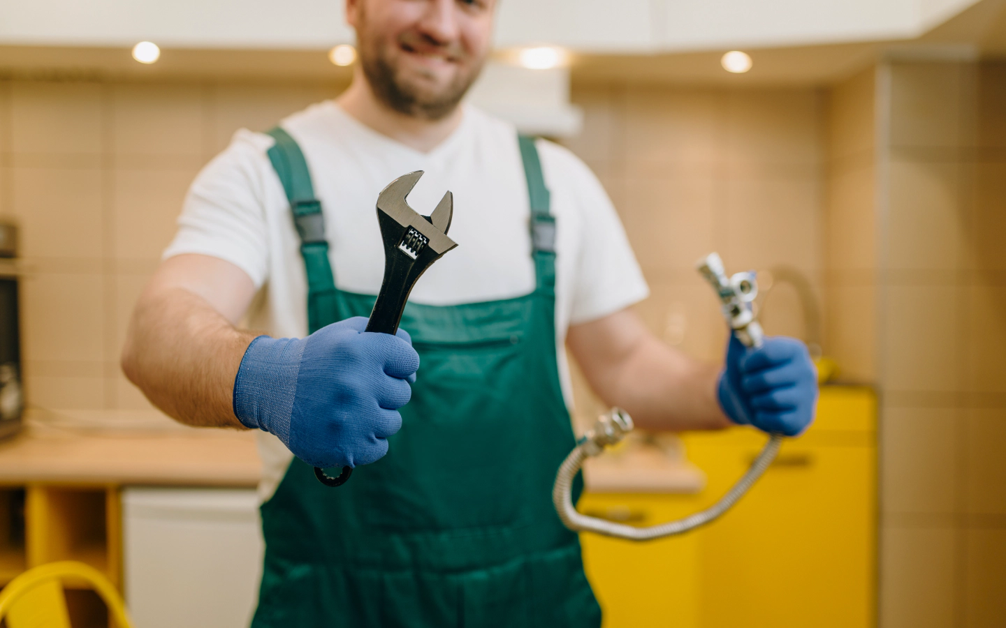 man holding a wrench and a pipe